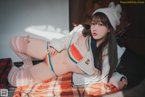 A woman in a bikini sitting on a bed.