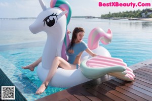 A woman in a white bodysuit sitting in a swimming pool.
