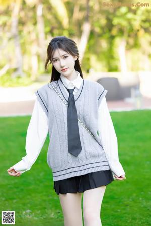 A young woman in a school uniform posing for a picture.