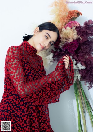 A woman in a red and black dress posing for a picture.