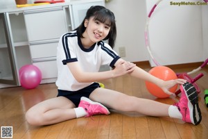 A young woman is playing with a hula hoop.