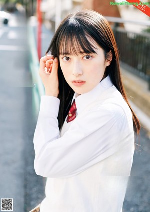 A woman in a gray suit and red tie posing for a magazine.