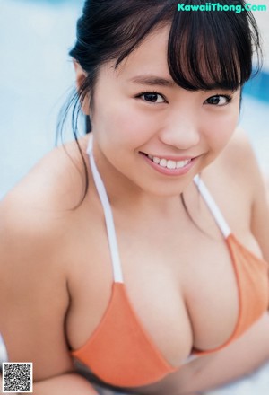 A woman in a red bikini holding a white shirt over her shoulder.
