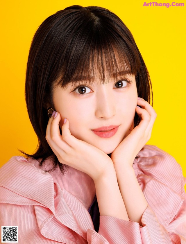 A woman in a pink shirt is posing for a picture.