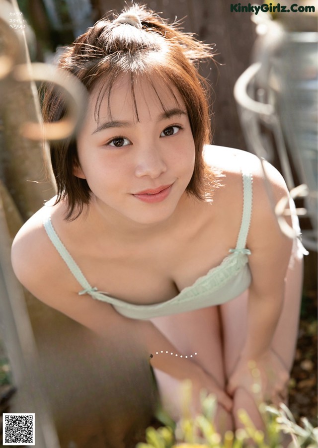 a japanese woman in a green bra top is posing for the camera