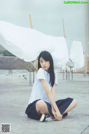 A woman in a black top and striped pants on a boat.