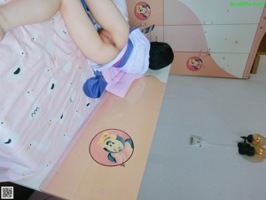 A woman sitting on a bed holding a cell phone.