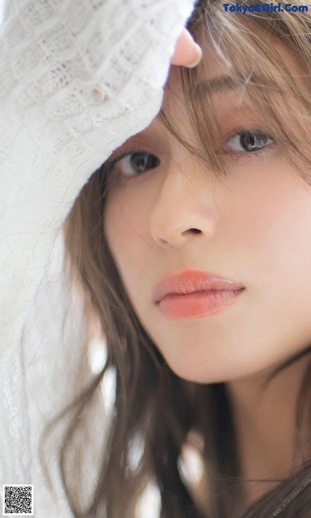 A woman with long brown hair wearing a white hat.