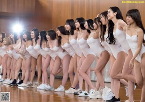 A group of young women in white bathing suits posing for a picture.