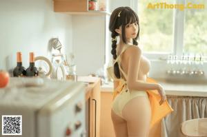 A woman with long black hair is sitting on a kitchen counter.