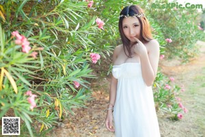 A woman in a blue shirt and white bikini posing for the camera.