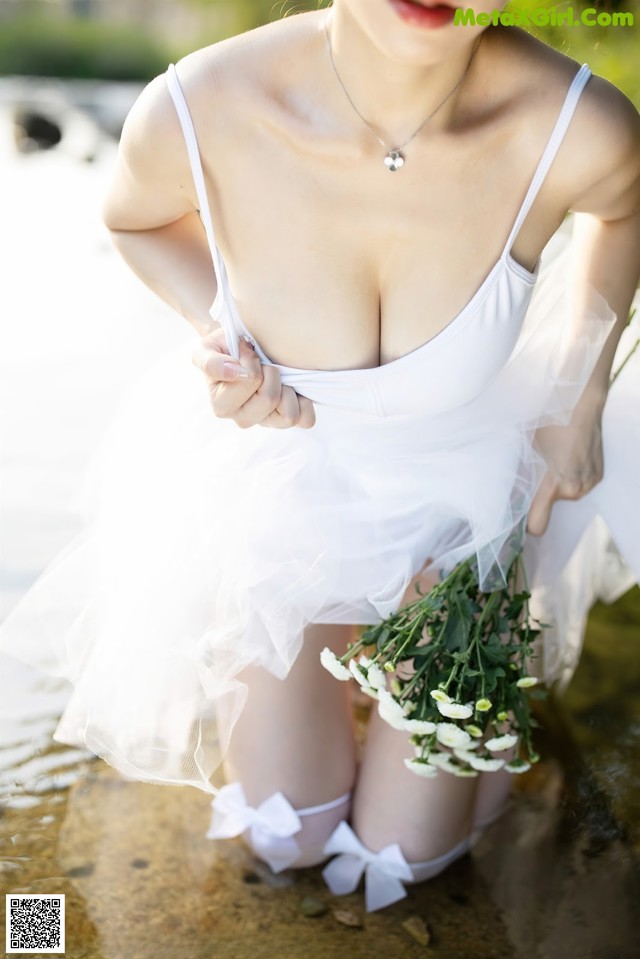 A woman in a white dress holding a bouquet of flowers.