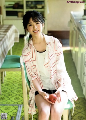 A woman holding an apple in her hand. 