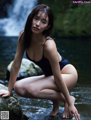 A woman in a white towel smiles at the camera.